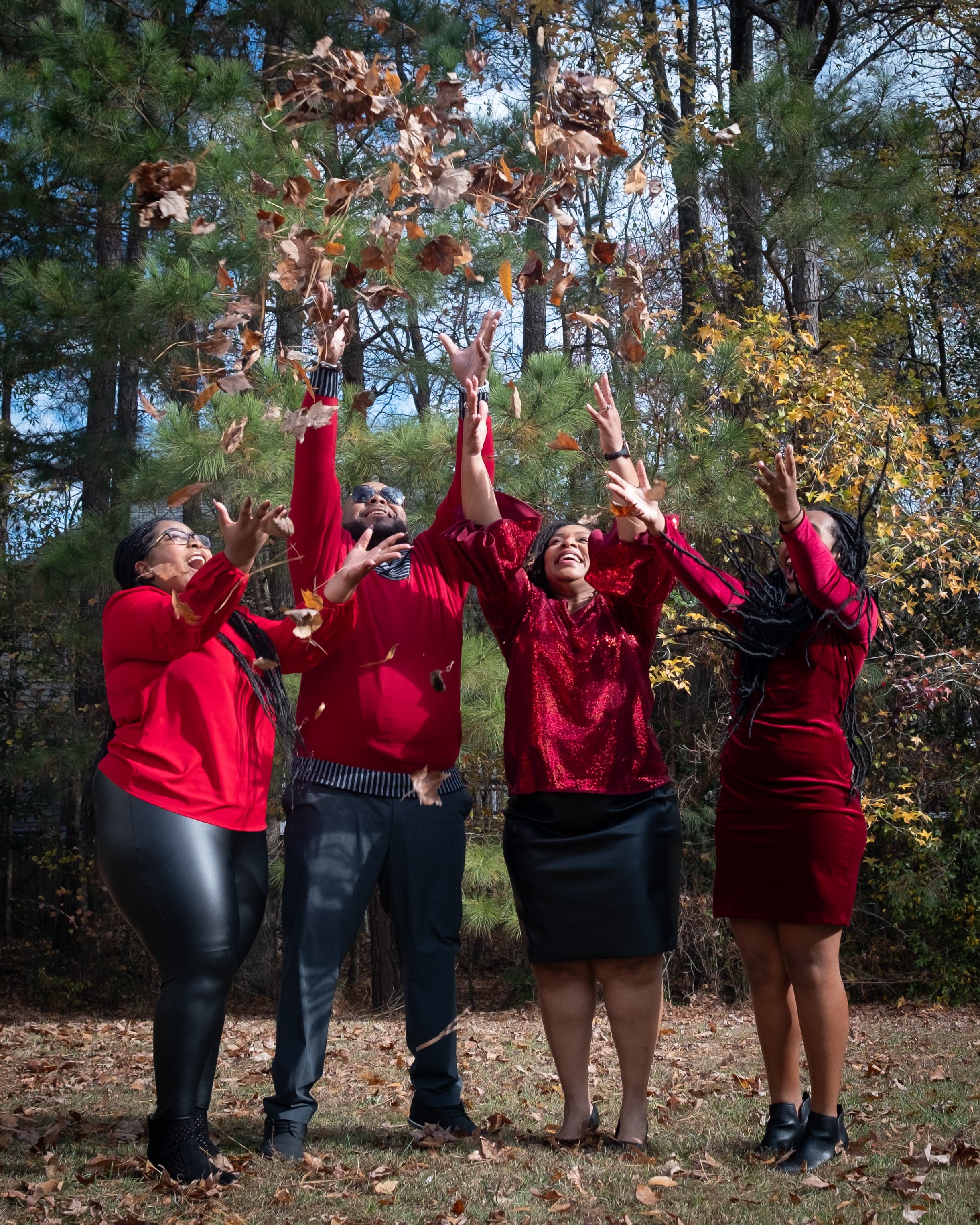 Group catching falling leaves in golden light