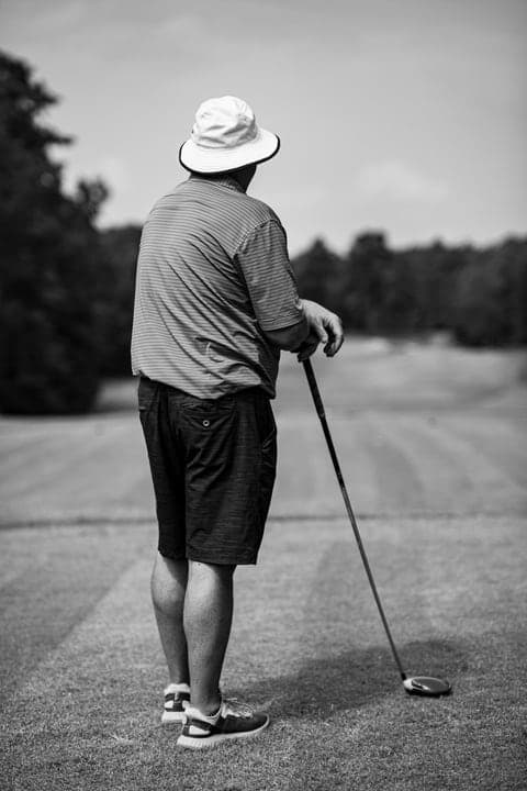 Black and white portrait of a golfer teeing off