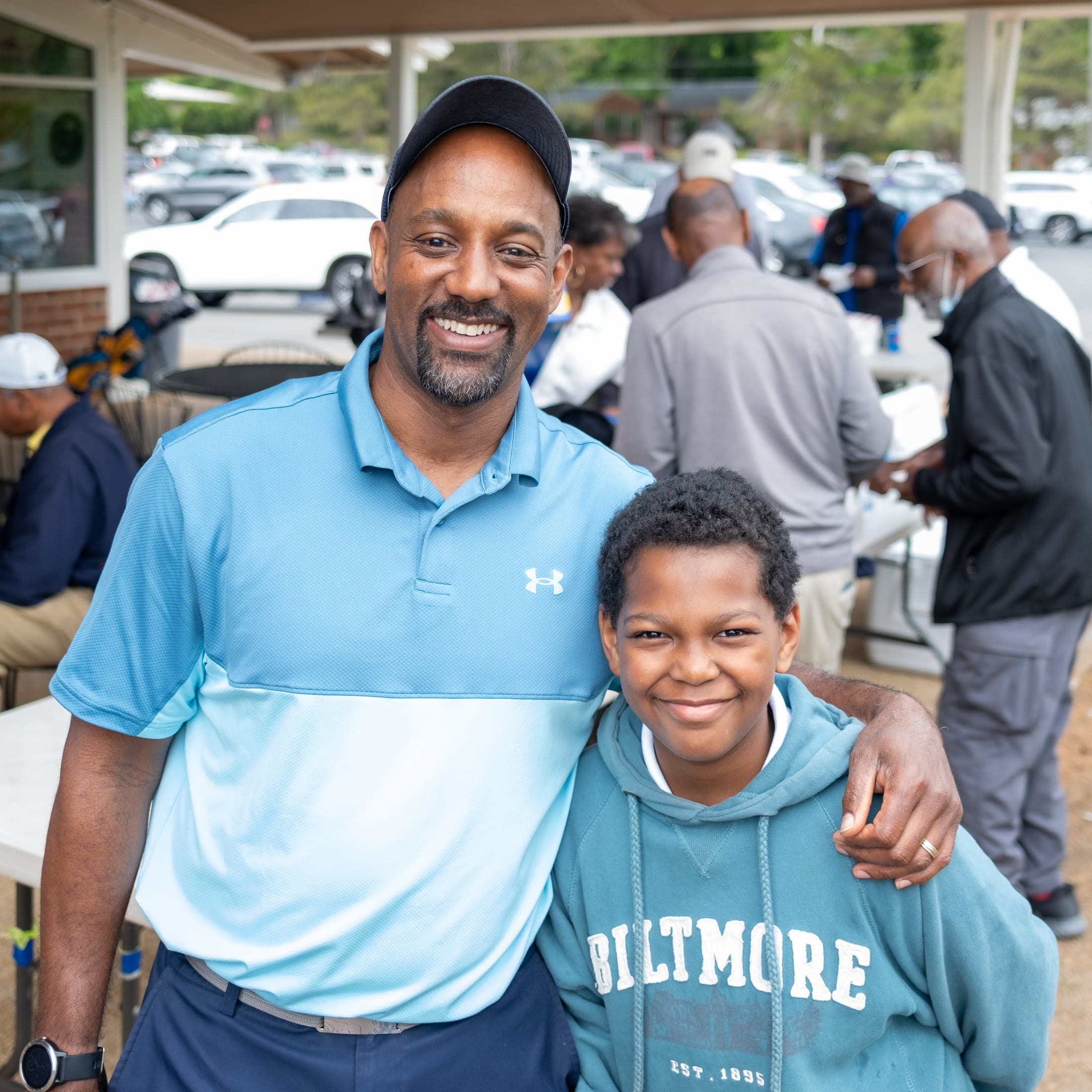 Golfer posing with his son at a tournament