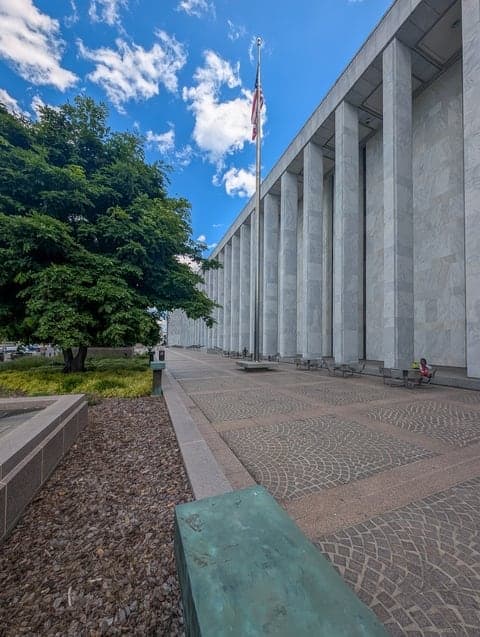 State Capitol colonnade with flag, downtown Raleigh