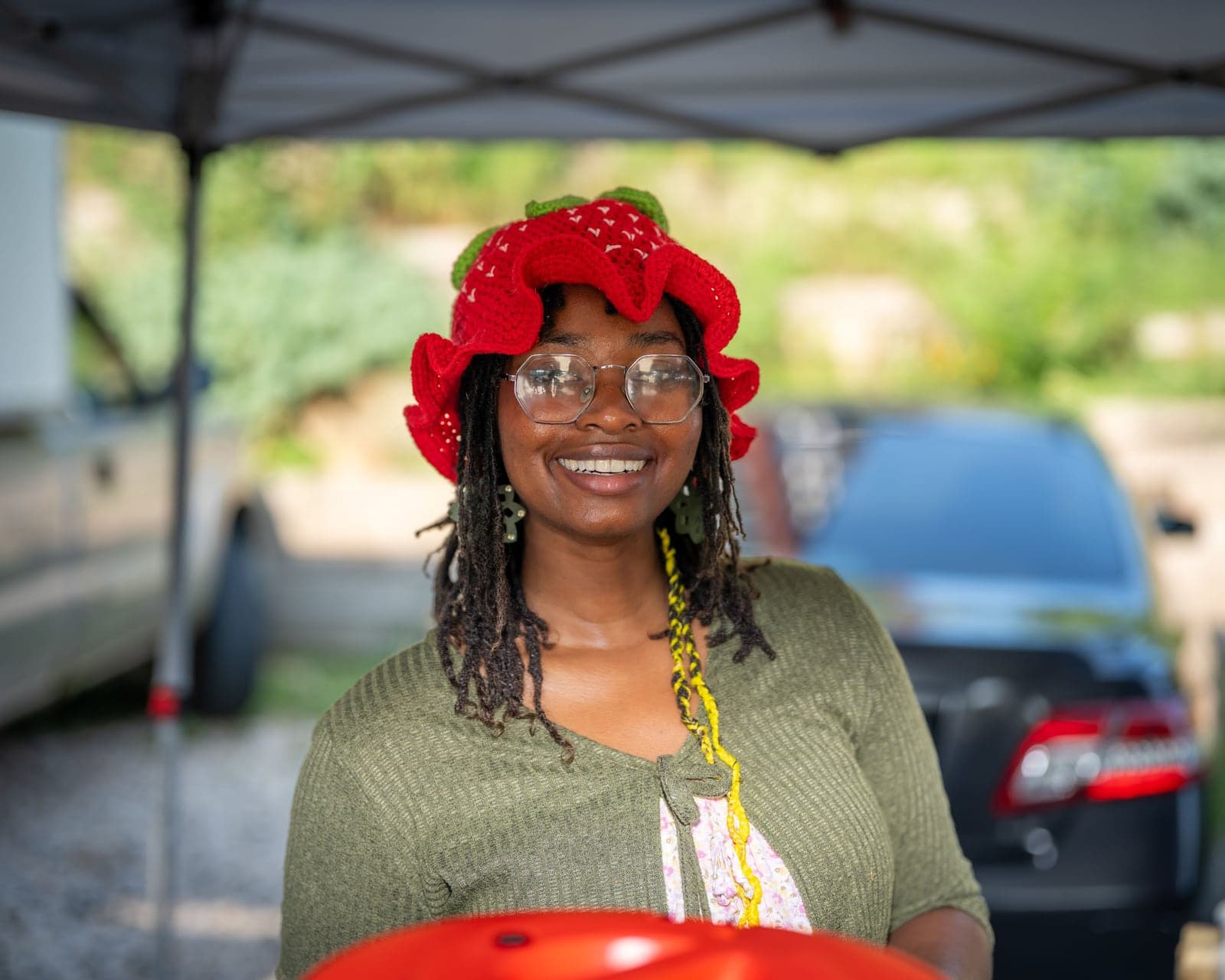 Vendor in a strawberry hat, market portrait