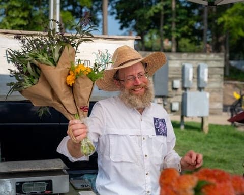 Farmers market vendor with a fresh flower bouquet