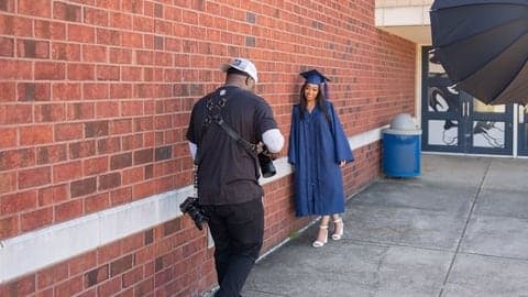 Photographing a graduate against a brick wall
