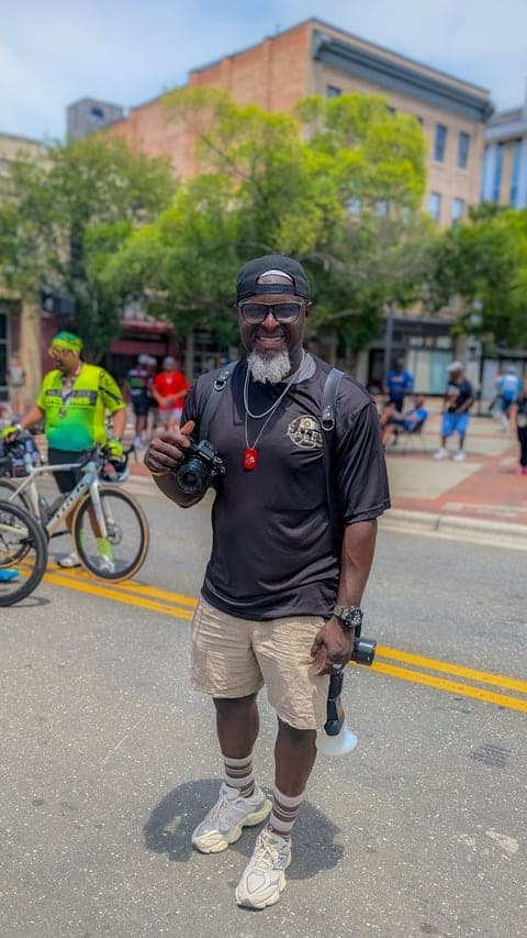 Holding his camera at a downtown street festival